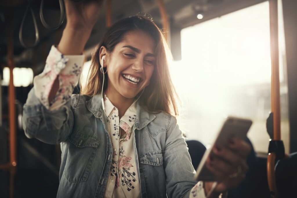 Smiling young woman riding a bus listening to music