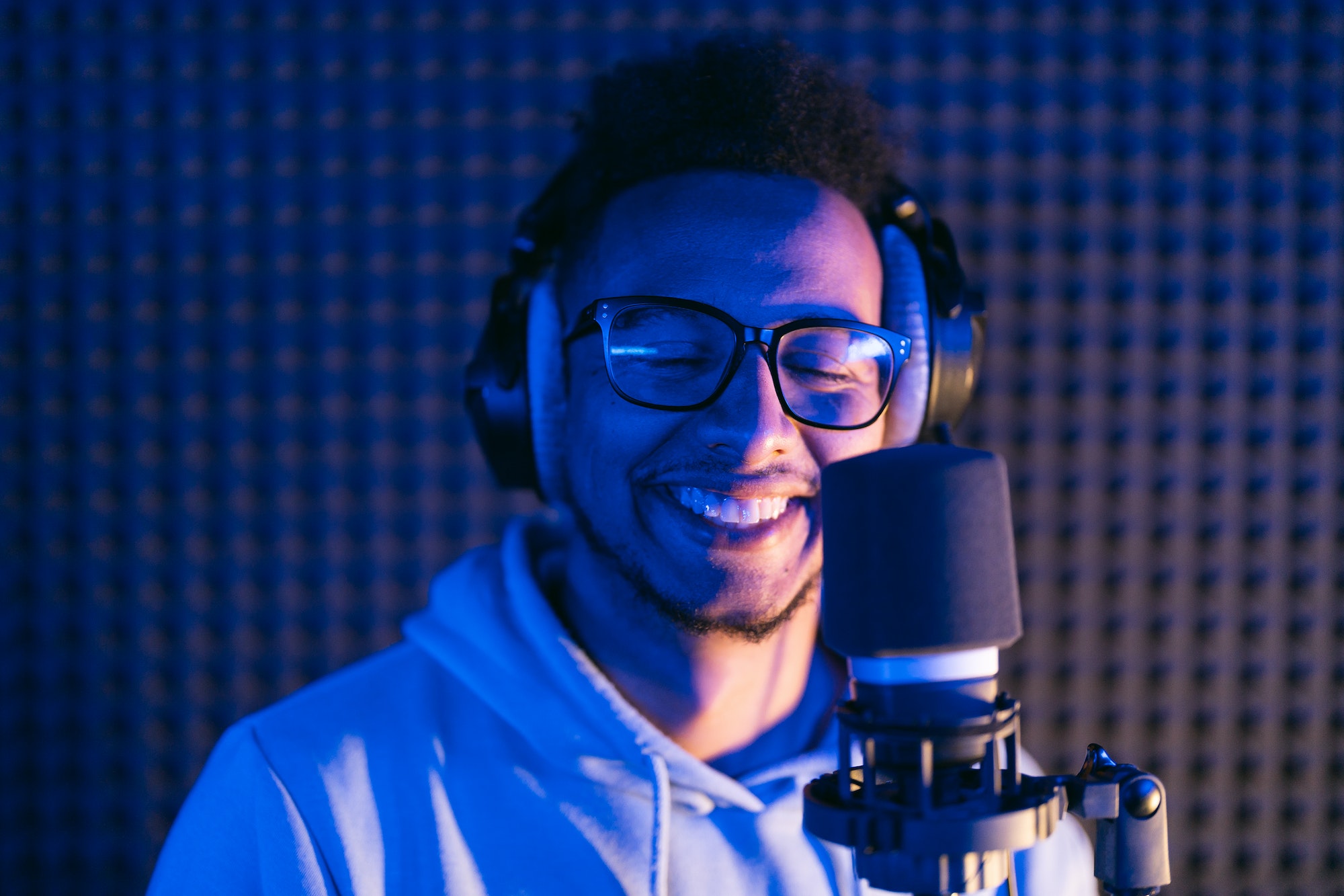 Young male singer in recording studio performing in neon lights